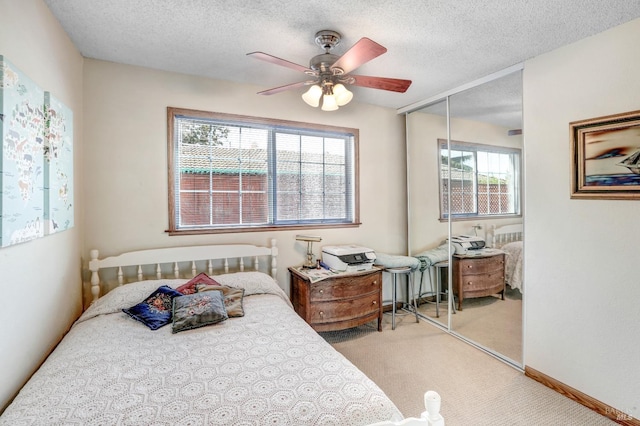 carpeted bedroom with a closet, a textured ceiling, and ceiling fan