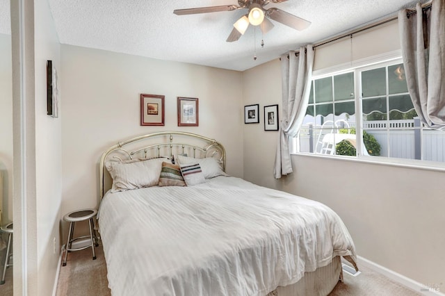 carpeted bedroom with a textured ceiling and ceiling fan