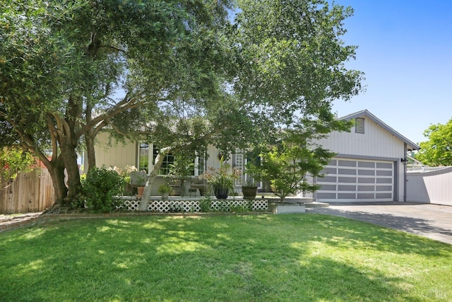 obstructed view of property with a front lawn and a garage