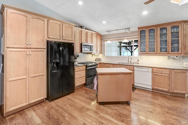 kitchen featuring vaulted ceiling, black appliances, a textured ceiling, sink, and light hardwood / wood-style flooring