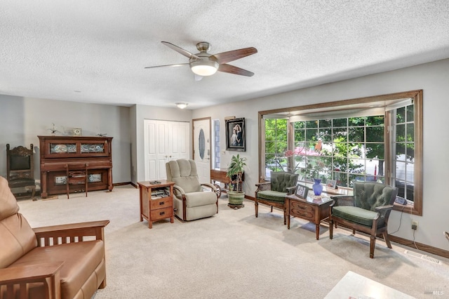 carpeted living room with a textured ceiling and ceiling fan