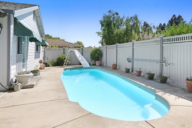 view of swimming pool featuring a water slide and a patio area