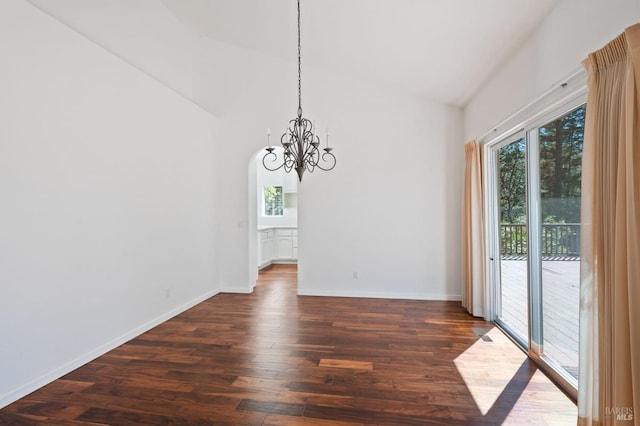 spare room with a notable chandelier, high vaulted ceiling, and dark hardwood / wood-style floors