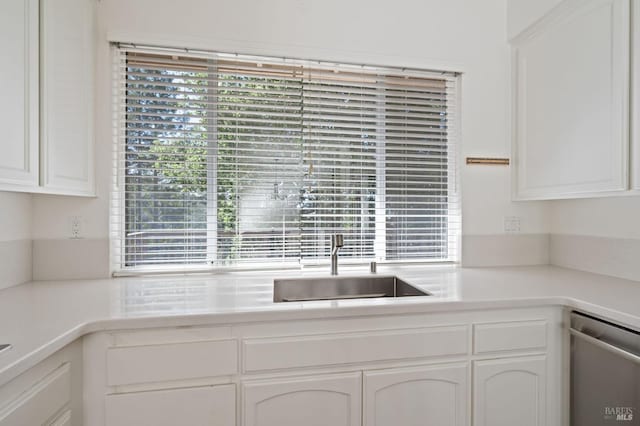 kitchen featuring dishwasher, white cabinets, and sink