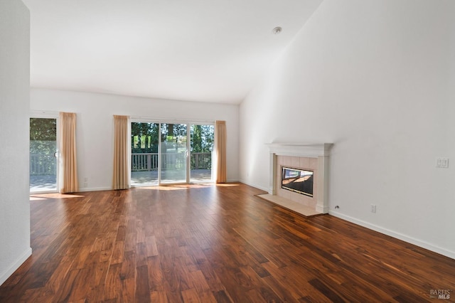 unfurnished living room with dark hardwood / wood-style floors and a tile fireplace