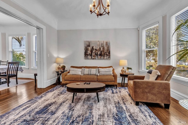 living room with a notable chandelier, baseboards, and wood finished floors