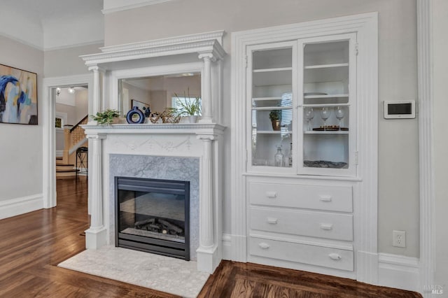 details featuring a fireplace, baseboards, and wood finished floors