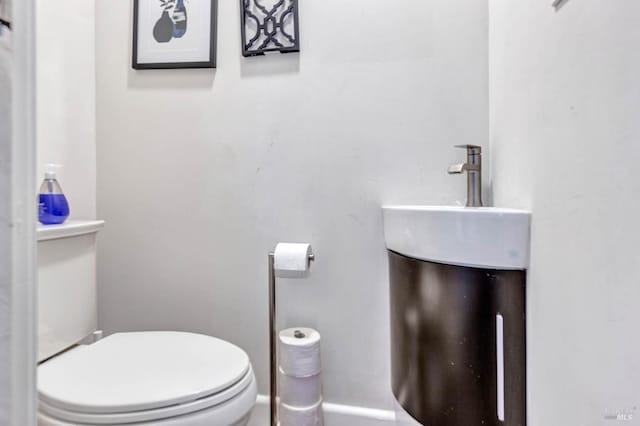 bathroom with baseboards and toilet