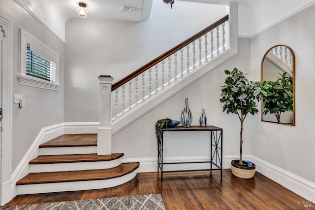 staircase with wood finished floors and baseboards