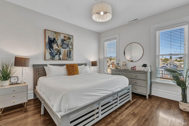 bedroom with baseboards, visible vents, and dark wood finished floors