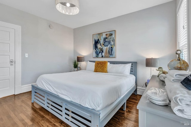 bedroom with baseboards and wood finished floors