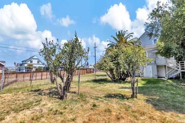 view of yard featuring fence and stairway