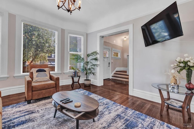 living area with a chandelier, stairway, wood finished floors, and baseboards