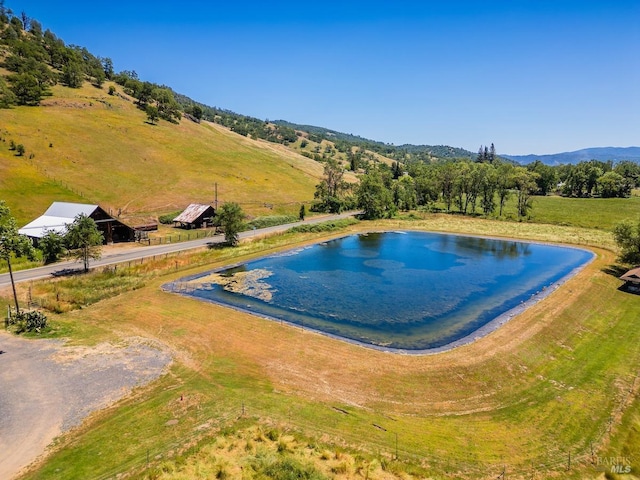 view of pool with a rural view and a water view