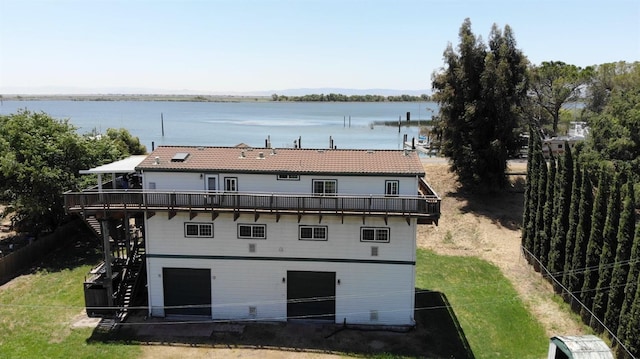 back of property featuring a garage and a water view