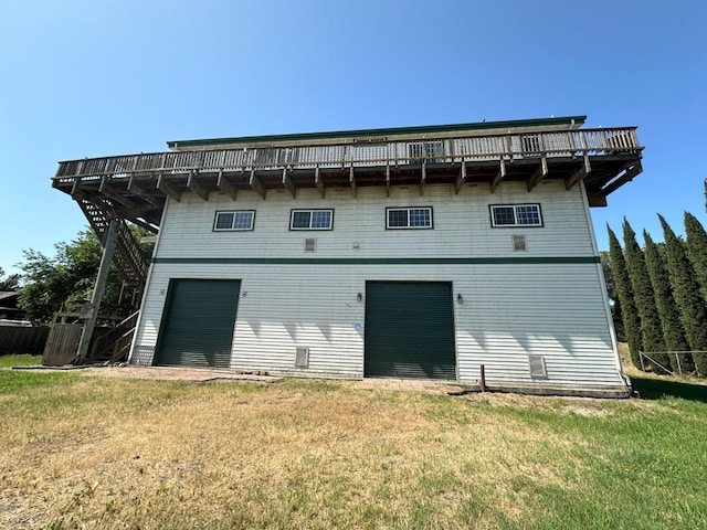 back of house featuring a garage and a yard