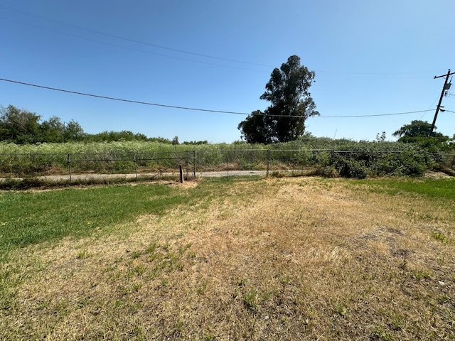view of yard with fence and a rural view