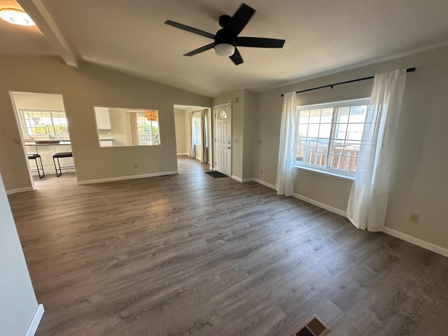 unfurnished living room featuring dark wood-style floors, a healthy amount of sunlight, and lofted ceiling with beams