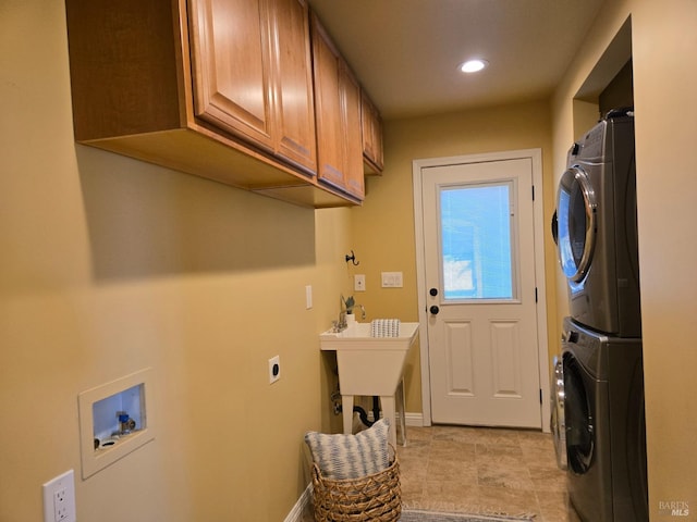 laundry room with cabinets and stacked washing maching and dryer