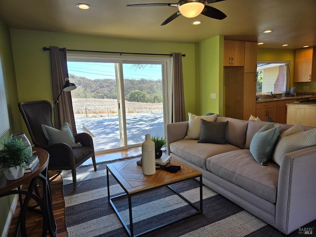 living room with dark wood-type flooring and ceiling fan