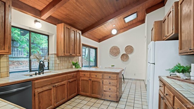 kitchen with tile countertops, dishwasher, and plenty of natural light