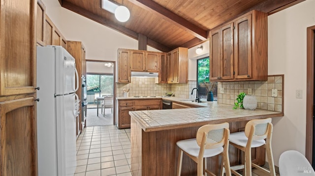 kitchen featuring sink, wooden ceiling, vaulted ceiling with beams, white refrigerator, and kitchen peninsula