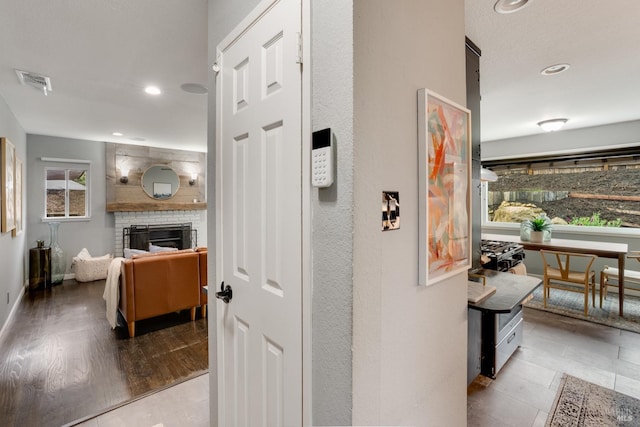 hallway with light wood-style floors, recessed lighting, visible vents, and baseboards