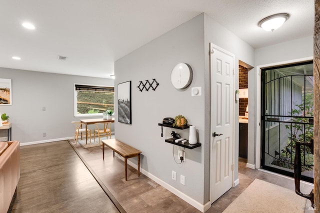 hall featuring recessed lighting, visible vents, baseboards, and wood finished floors