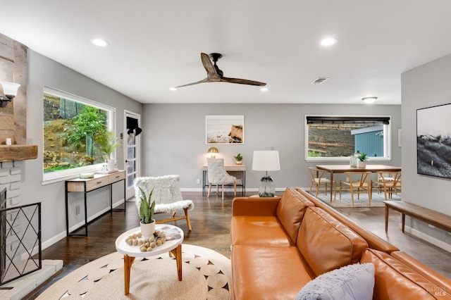 living room featuring a large fireplace, baseboards, dark wood-style floors, and recessed lighting