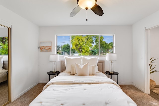 carpeted bedroom featuring ceiling fan, multiple windows, and baseboards