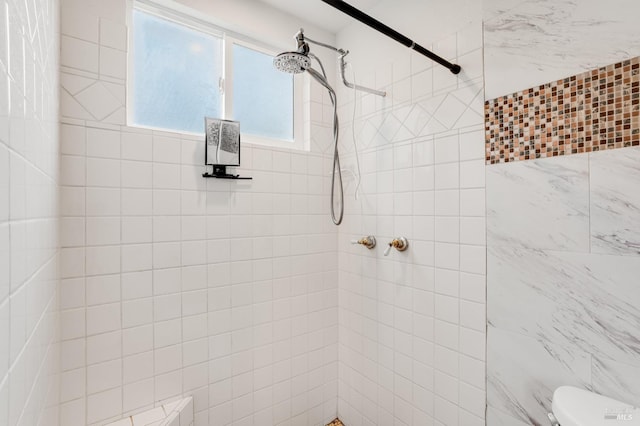 bathroom with tiled shower and toilet