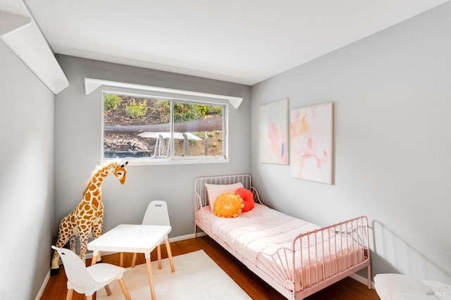 bedroom featuring baseboards and wood finished floors