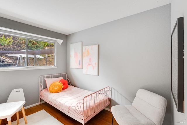 bedroom with baseboards and wood finished floors