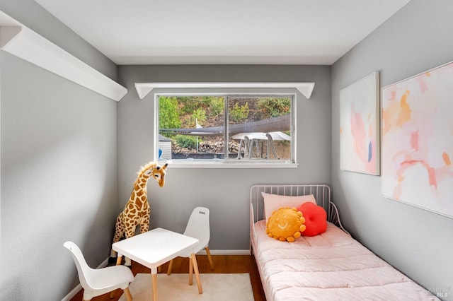 bedroom featuring wood finished floors and baseboards