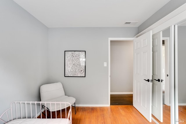 bedroom featuring visible vents, light wood-style flooring, and baseboards