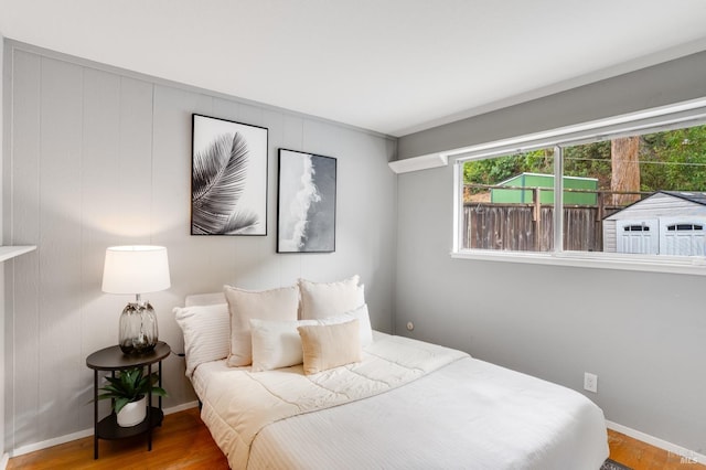 bedroom with baseboards and wood finished floors