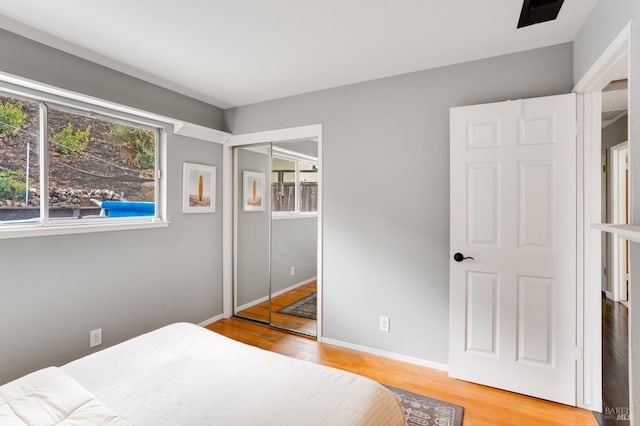 bedroom featuring a closet, baseboards, and wood finished floors