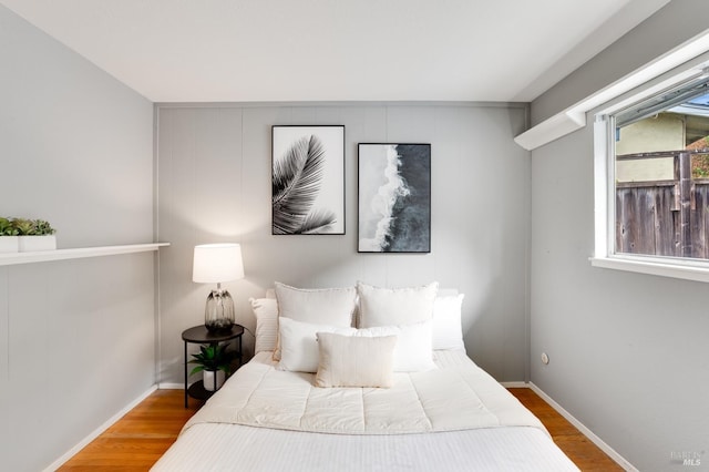 bedroom featuring baseboards and wood finished floors