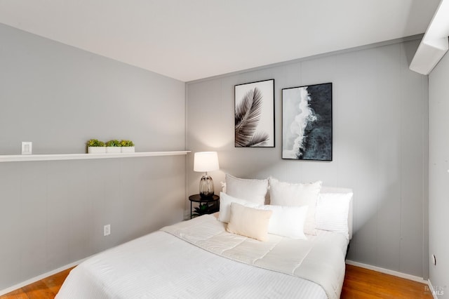 bedroom featuring wood finished floors and baseboards