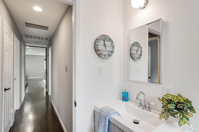 bathroom featuring vanity, wood finished floors, visible vents, and baseboards