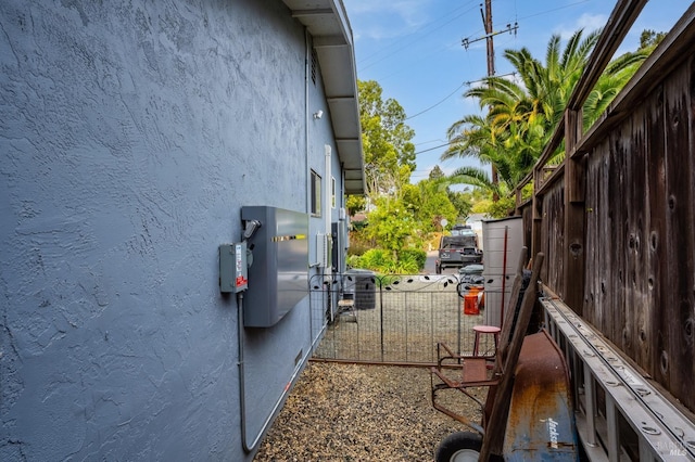 view of side of property with fence and stucco siding