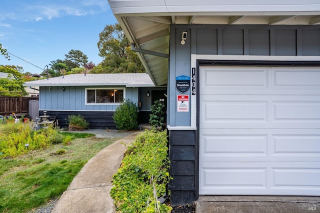 view of exterior entry with board and batten siding and an attached garage