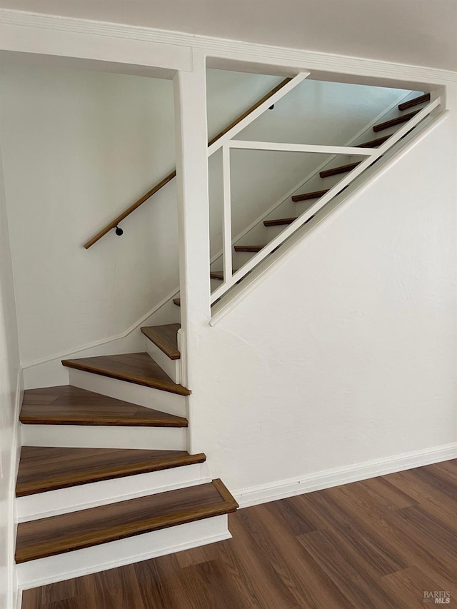 staircase with dark wood-type flooring