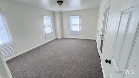 unfurnished bedroom featuring dark colored carpet