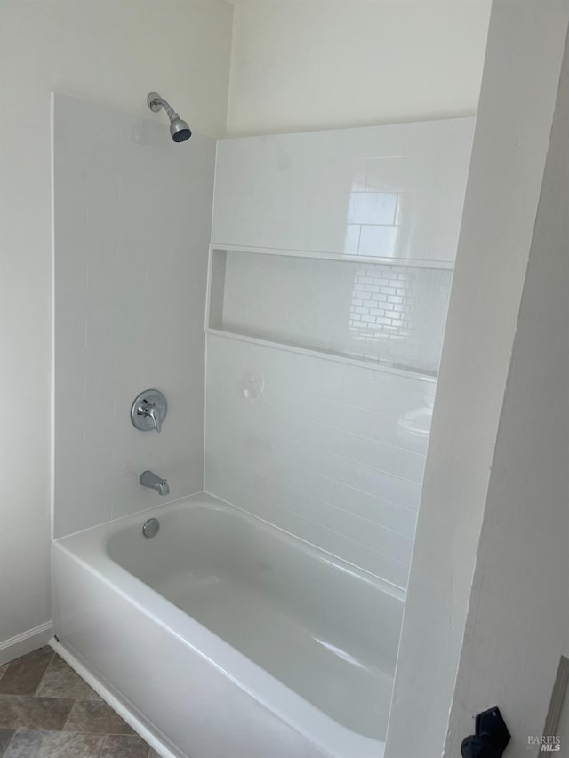 bathroom with tile floors and tiled shower / bath combo