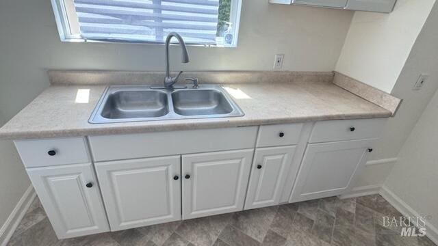 kitchen featuring white cabinets, sink, and tile floors