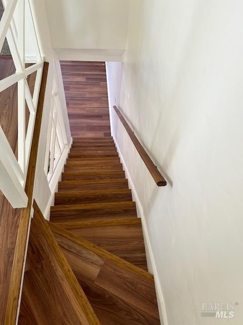 stairs featuring dark wood-type flooring