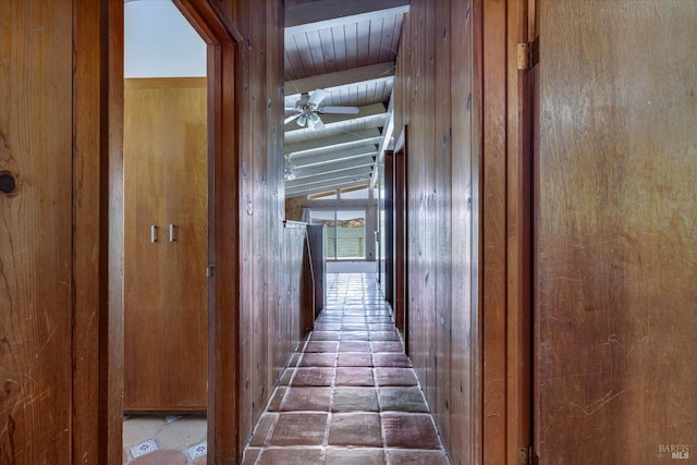 hall featuring vaulted ceiling with beams and wooden walls