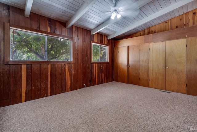 interior space featuring lofted ceiling with beams, wood walls, wood ceiling, and ceiling fan