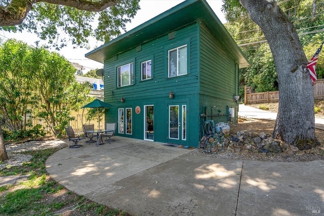 rear view of house featuring a patio area and fence